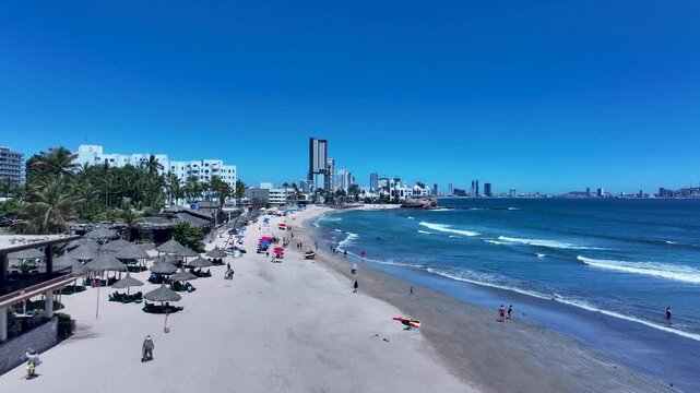 Aerial Mexico Mazatlan city sandy beach. Commercial ocean vacation tourism seaport, cargo and cruise ships. Luxury resort Mexican Riviera. Romantic destination. Sand, surf and beach recreation travel.