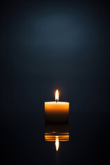 Candle with reflection on dark blue background