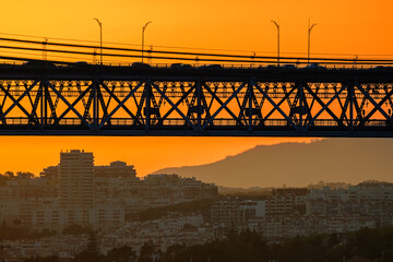 25 de Abril bridge silhouette over Lisbon at sunset with orange sky