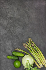 Asparagus, cucumbers, lime and kohlrabi on table