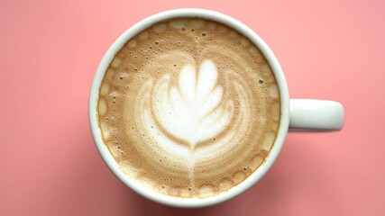 Top Down View of Latte Art Cappuccino in White Mug with Rich Foam and Detailed Leaf Pattern on Pink Background Coffee Shop Culinary Theme Beverage