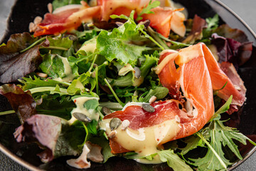 Salad jamon meat green leaf lettuce appetizer food fresh gourmet food background on the table rustic food top view copy space