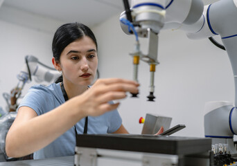 Hispanic engineer woman working on AI technology in robotics electronics engineering laboratory. University students' research project is programming robot machine with intelligent mechanical control