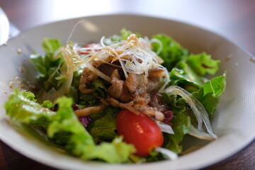 Beef Salad warm salad with veal, lettuce mix and grilled vegetables - mushrooms, eggplant, zucchini, tomatoes in ceramic plate on wooden table. Selective focus