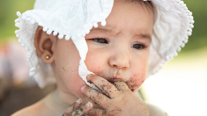 baby girl eating sand on the beach
