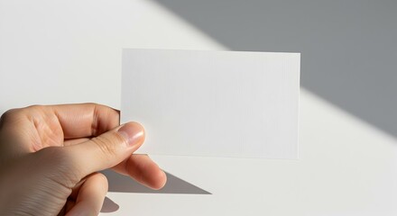 Fototapeta premium Blank Card Mockup on Wooden Floor with Subtle Light and Shadow