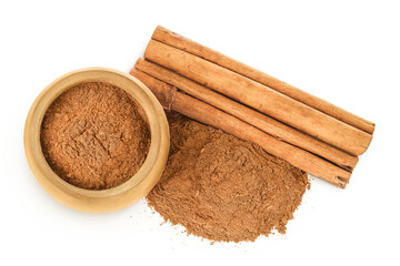 Cinnamon sticks with powder in wooden bowl isolated on white background. Top view. Flat lay.