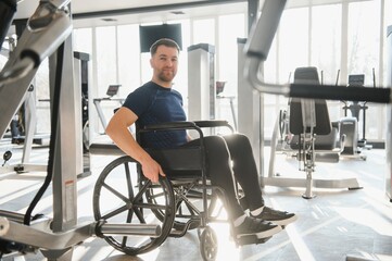 Man with disability training in wheelchair at gym for rehabilitation