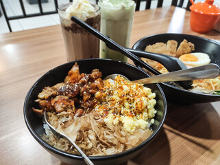 Table top view A bowl of Japanese style meat and ramen rice. Complete ramen and rice dish with iced chocolate and iced matcha latte drinks. Dinner for couples. Food and Beverages themes.