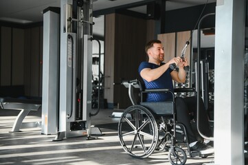 Man in wheelchair working out at the gym with cable machine