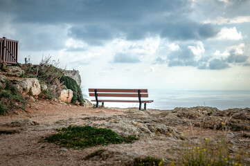 Wooden forged bench on the cliffs with view of sea. Dingli cliff's, Malta. Nice place with a view on the Sea and the horizon.