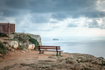Lonely bench on the edge of cliff on sunny day in Malta. Dingli cliff's, Malta.