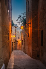 Fototapeta premium Beautiful view of ancient narrow medieval street town Mdina, Malta. Twilight.