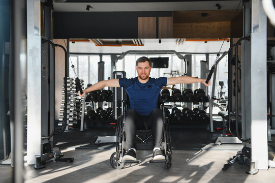 Man in wheelchair exercising in modern gym