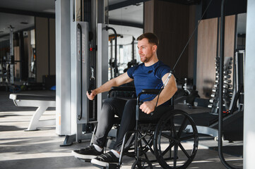 Man with disability performing rehabilitation exercises with cable machine in gym
