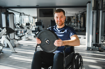 Man with disability athlete lifting weights in wheelchair at gym for rehabilitation