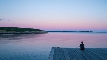 Fototapeta premium A person sitting on a dock, gazing at the calm sea under pastel skies