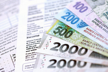 Argentine pesos money bills in big amount lies on table with pen and tax forms close up