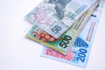 Argentine pesos money bills in big amount lies on white table close up