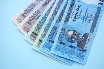 Bangladeshi taka money bills in big amount lies on teal color table close up