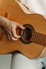 Fototapeta premium Close-up of a person's hands playing an acoustic guitar