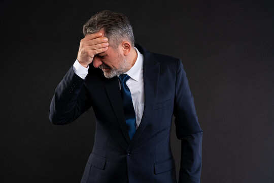 Frustrated businessman holding head in despair.