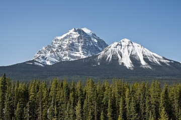 Majestic snow-capped mountain peaks under clear blue sky.