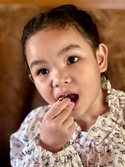 Portrait of a little girl eating sweet food