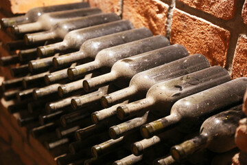 Wine ripens in moldy bottles in a rural cellar. Vineyard background
