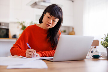 Woman working remotely from home doing paperwork
