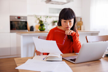 Woman doing paperwork while working remotely from home