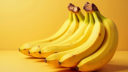 A vibrant bunch of ripe yellow bananas arranged on a matching colored surface