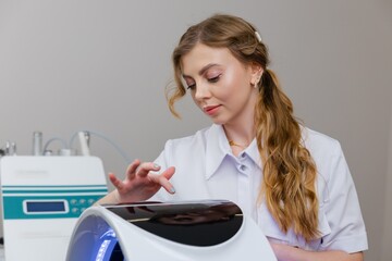 Beautician using led light therapy machine for skin rejuvenation