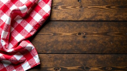 Obraz premium Red and White Checkered Cloth Draped on Rustic Wooden Surface, Perfect for Culinary or Rustic Themed Designs