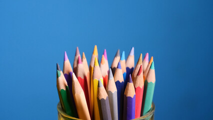 Creative Palette: A collection of vibrant colored pencils bursts with energy and imagination, set against a vivid blue backdrop, inviting artistic expression and playful exploration.
