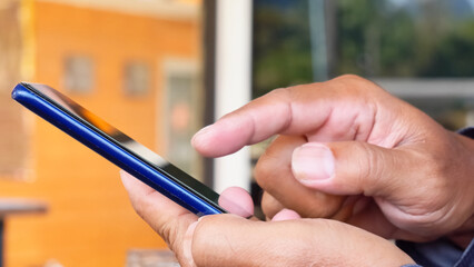 Tapping the Digital Realm: Focused hands skillfully interact with a sleek smartphone, immersed in the realm of digital communication.