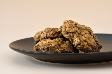 Homemade oatmeal cookies. Side view of a stacked oatmeal cookie on a dark plate . Bakery. Vegetarian food. Healthy breakfast .