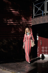 street style fashion girl model in red dress on the street.