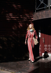 street style fashion girl model in red dress on the street.