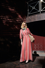 Naklejka premium street style fashion girl model in red dress on the street.