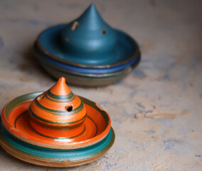 Colorful wet clay art moulded by indian potters and kept for drying with bokeh background of other clay pots.Image for pottery,artwork,workshops,webinars,creation,craft.Complex clay sculpture display