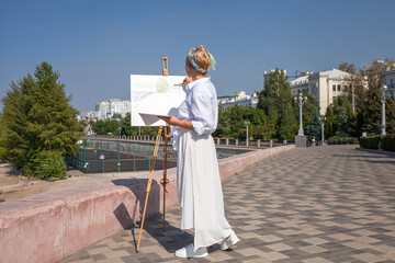 Obraz premium Female artist paints a cityscape in Samara