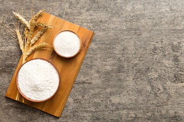 Flat lay of Wheat flour in wooden bowl with wheat spikelets on colored background. world wheat crisis