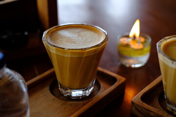 Burning Oil Candle with Two Cups of Cappuccino in the Background