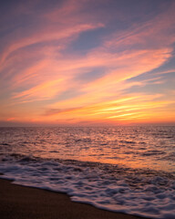 Obraz premium Colorful sunset over the calm ocean waves