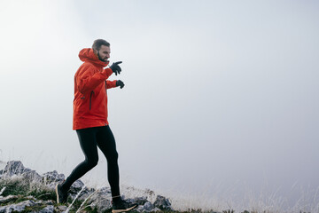 Man Climbing Rocky Hill in Fog