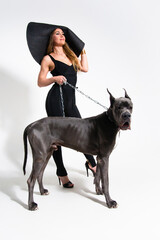 Beautiful slender model dressed in the black suit with dog