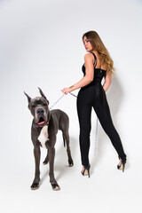 Beautiful slender model dressed in the black suit with dog