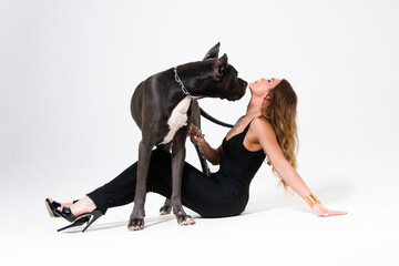 Beautiful slender model dressed in the black suit with dog