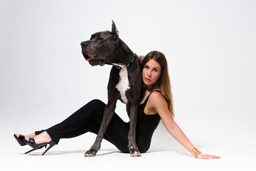 Beautiful slender model dressed in the black suit with dog